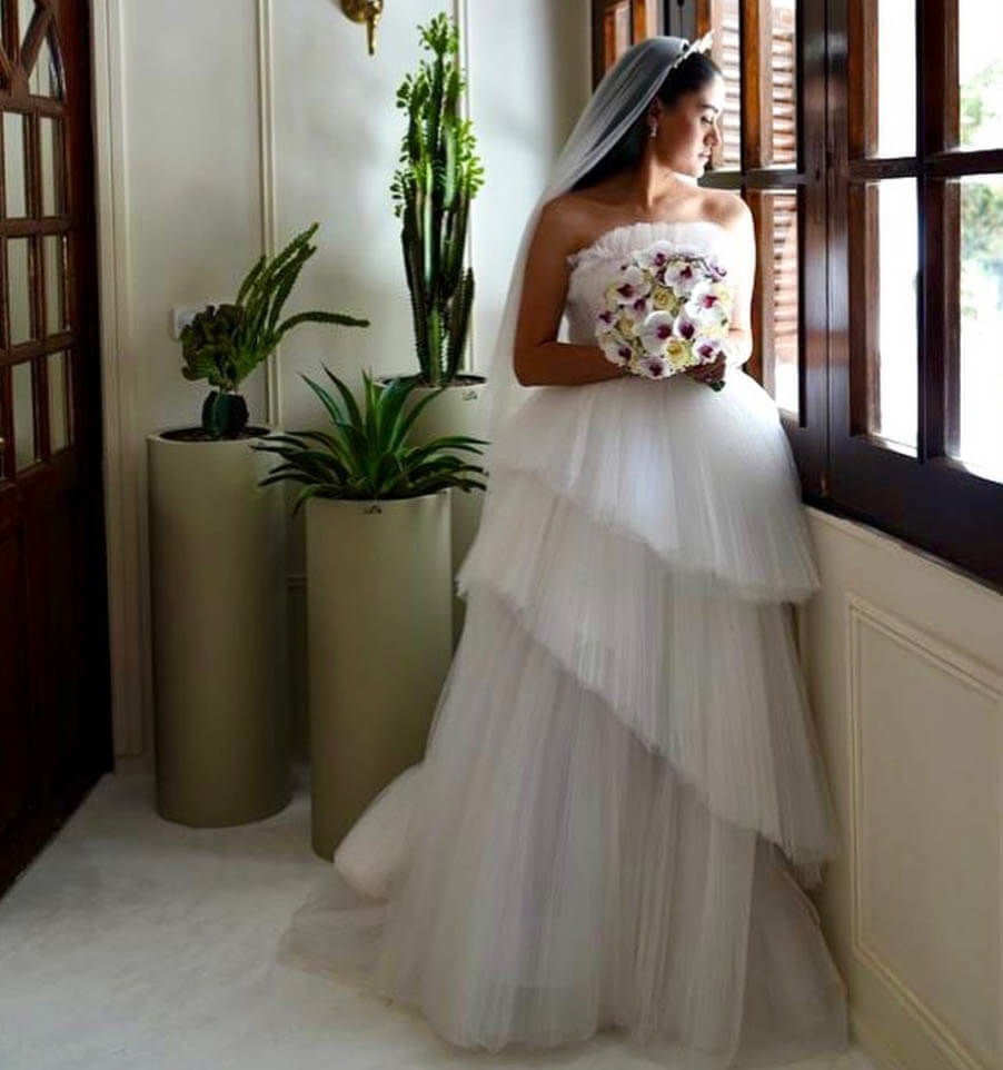 Model wearing a white gown near the window